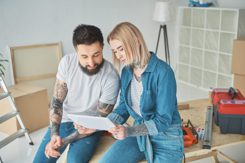 beautiful young couple using digital tablet during home improvement